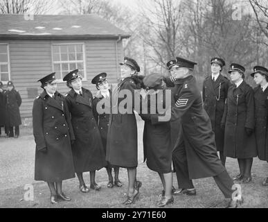 Die British RAILWAYS POLICE TRAINING School in St. Cross. Walton-on-the-Hill, Tadworth, Surrey, wurde heute (Freitag) von Lieut-Colonel Sir Hugh Turnball, Commissioner of Police, City of London, offiziell als Wohnschule eröffnet. DAS BILD ZEIGT: Sgt. BERNARD LAFLIN, zeigt LORNA MITCHAM, eine Polizistin, wie man Druck auf KITTY HOLGARTH, auch Polizistin, während einer Ausstellung zur Selbstverteidigung ausübt, die Teil des Programms der Eröffnung der neuen Eisenbahnpolizeischule war. 17. Dezember 1948 Stockfoto