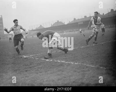 Ein aufregender Moment während des Spiels der Football Association in der zweiten Runde zwischen dem Amateurverein Walthmanstow Avenue und Oldham Athletic in Walthmanstow, stürmt LondonF.L.Lewis (Walthmanstow) ein, aber JONES (Torhüter Oldham) sammelt den Ball, um sein Tor freizugeben. 11. Dezember 1948 Stockfoto