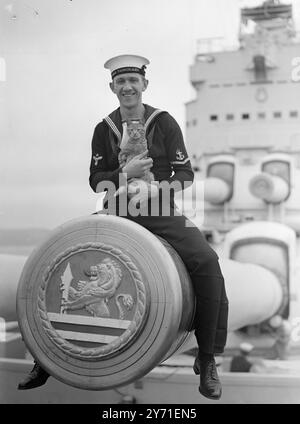 AVANTGARDE BEREITET SICH AUF DIE ROYAL AUSTRALIAN TOUR VOR. Die Crew von H.M.S. Vanguard freut sich mit großer Erwartung auf die Royal Tour durch Australasien im nächsten Jahr und ist zu Recht stolz auf ihre Verbindung mit diesem großartigen Schiff, das jetzt in der Weymouth Bay (Dorset) liegt. Vor einer Shakedown-Kreuzfahrt nach Gibraltar und Malta am nächsten Freitag. Das Schiff erhält den letzten Schliff für die Tour, als sie nach Devonport zurückkehrt, DAS BILD ZEIGT: Leading Stoker A. WALKER aus Nottingham ragt auf einer der Kanonen der Vanguard und hält Rastus, das Maskottchen des Schiffes. 10. September 1948 Stockfoto