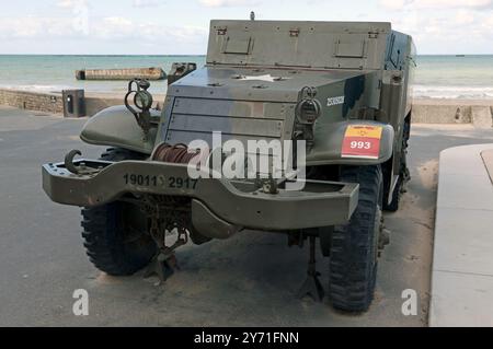 Ein amerikanischer M3-Halb-Track-gepanzerter Personnel Carrier in Arromanches-les-Bains, Normandie, Frankreich, dahinter Teile des Mulberry Harbour zu sehen sind. Stockfoto