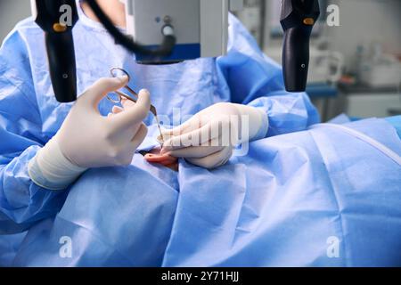 Mitarbeiter der modernen Klinik verwenden während des Betriebs spezielle optische Geräte Stockfoto