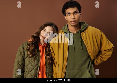 Ein modisches junges Paar zeigt seine lebhaften Herbstoutfits und teilt einen Moment miteinander. Stockfoto