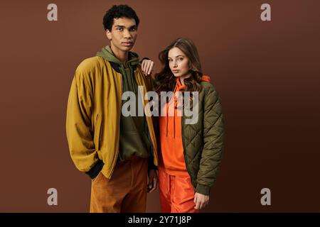 Ein junges Paar präsentiert seine modischen Herbstoutfits mit saisonalen Farben und Styles. Stockfoto