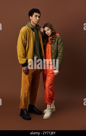 Ein stilvolles Paar präsentiert trendige Herbstoutfits in kräftigen, lebhaften Farben und strahlt Wärme aus. Stockfoto