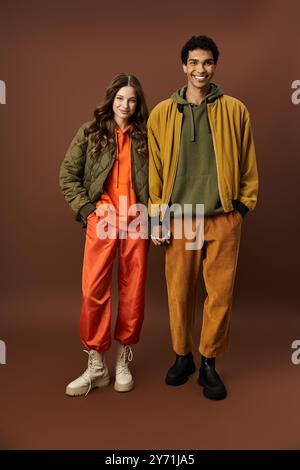 Ein stilvolles Paar präsentiert seine herbstliche Mode in lebhaften Farben und gemütlichen Outfits. Stockfoto