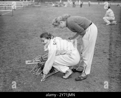 Die Polytechnischen Harriers hielten die TROPHÄEN " SWARD " im Quintin Hogg Memorial Ground in Chiswick ab . An den Sonderveranstaltungen nahmen viele "Possibles " der Olympischen Spiele Teil . DAS BILD ZEIGT:- Rekordzahl gewinnen - Miss MAUREEN GARDNER hat ihre Nummer vor dem Start des 80 Meter langen Einladungshürdenrennens in Chiswick angepasst . Mai 1948 Stockfoto