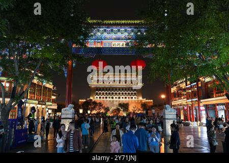 Peking, China. September 2024. Touristen besuchen die Qianmen-Straße und den Pfeilturm des Zhengyang-Tors in Peking, der Hauptstadt Chinas, 26. September 2024. Peking wird vom 29. September bis 7. Oktober über 2.800 Nachtbeleuchtungsanlagen aktivieren, um den 75. Jahrestag der Gründung der Volksrepublik China zu feiern. Verbesserte Beleuchtungseffekte werden auf Wahrzeichen entlang der Pekinger Zentralachse angewendet, wie das Yongding-Tor und die Glocken- und Trommeltürme für den bevorstehenden Nationalfeiertag. Quelle: Ju Huanzong/Xinhua/Alamy Live News Stockfoto