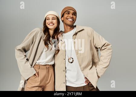 Ein modisches Paar präsentiert ihre herbstlichen Styles mit einem Lächeln und strahlt Wärme und Freude aus. Stockfoto