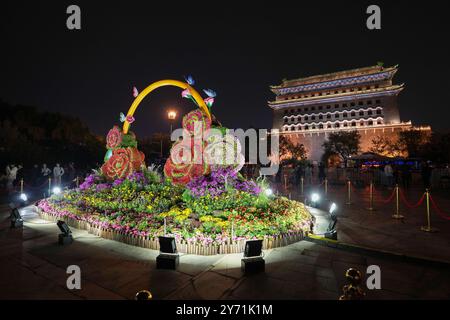 Peking, China. September 2024. Touristen besuchen die Qianmen-Straße und den Pfeilturm des Zhengyang-Tors in Peking, der Hauptstadt Chinas, 26. September 2024. Peking wird vom 29. September bis 7. Oktober über 2.800 Nachtbeleuchtungsanlagen aktivieren, um den 75. Jahrestag der Gründung der Volksrepublik China zu feiern. Verbesserte Beleuchtungseffekte werden auf Wahrzeichen entlang der Pekinger Zentralachse angewendet, wie das Yongding-Tor und die Glocken- und Trommeltürme für den bevorstehenden Nationalfeiertag. Quelle: Ju Huanzong/Xinhua/Alamy Live News Stockfoto