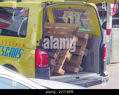 Cremona, Italien - 19. september 2023 der Van ist voll mit Holzpaletten und hat das Wort „Social“. Der Van steht vor einem Gebäude. Stockfoto