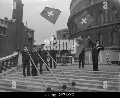 ALPHÖRNER BEI ALBERT HALL SWISS FOLKLORE FESTIVAL. Als spontane Geste zur Kriegsarbeit der RAF. Vom Basler Volk nehmen 165 Jodler , Bergsteiger und Musiker am SCHWEIZER FOLKLORE FESTIVAL Teil , das in der Royal Albert Hall eröffnet wird. High Light des Festivals ist das Spielen der 12 Fuß hohen hölzernen Alphörner . Der Erlös geht an die RAF . Wohltätigkeitsfonds . DAS BILD ZEIGT :- "AN DEN HÄNGEN DER ALBERT HALL " Schweizer Fahnenwerfer und Alphornspieler üben für das Festival auf den Stufen der Royal Albert Hall in London . Mai 1948 Stockfoto