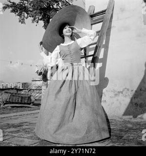 Eleganz auf dem Land Florenz, Italien : dieses elegante Kleid sieht aus wie etwas aus dem 19. Jahrhundert und eignet sich für Urlaube auf dem Land. Ein Modell aus der Frühjahr/Sommer-Kollektion 1965 von Gibo, Mailand und Florenz. Das lange, großzügige Kleid ist aus einer ausgefallenen grauen Baumwolle. Die String geschnürte Miederbluse rundet das Ensemble ab. Das elegante Outfit mit Glasrücken wird von einem Hut mit Blumenbesatz von einem Meter Durchmesser gekrönt. 20. Januar 1965 Stockfoto