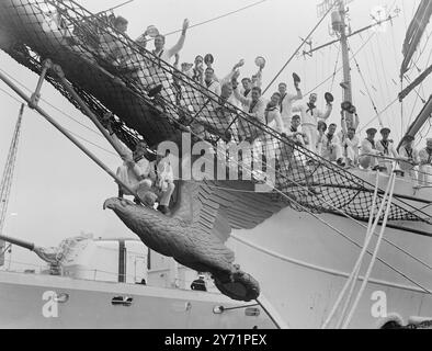 „Junior Salts“ – US-Schiffe auf Besuch die drei Mastbarque Eagle, ein amerikanisches Hilfsausbildungsschiff mit 170 Kadetten der United States Coastguard Academy, kam zusammen mit der US-Sloop Campbell nach London. Sie sind hier auf einer zehntägigen „Goodwill Training Cruise from America“. Das Bild zeigt: Geflügelte Seeleute Junge Marinekadetten grüßen England bei ihrer Ankunft im Shadwell Basin, London Docks, an Bord des Ausbildungsschiffs Eagle. Die beiden Salze auf der geschnitzten Galionsfigur sehen so viel wie ein Seemann zu Hause aus. Juli 1948 Stockfoto