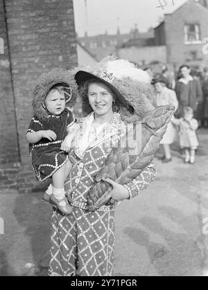 Diese beiden Vertreter von Finsbury, London, besuchten das Erntefest der Costermongers' Harvest in der St-Mary Magdalene Church in der Old Kent-Road. MARIE LOUISE MARRIOTT trägt den kleinen JEAN MARRIOTT, sowie ihr Ernteopfer - einen Brotlaib. Oktober 1948 Stockfoto