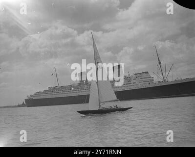 'Royal Yacht on Trials' 'Bluebottle', die Dragon Class Rennyacht, die ihren Königlichen Hoheiten, Prinzessin Elizabeth und dem Herzog von Edinburgh, vorgestellt wird, war heute auf Segelwegen vor Hamble, Hants, unterwegs. Das Bild zeigt: 'Royal Racer' - 'Bluebottle', der an dem größten Liner der Welt vorbeisegelt, dem Cunard White Star Liner 'Queen Elizabeth', der heute von New York in Southampton Waters aus heimwärts fährt. Juli 1948 Stockfoto