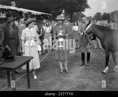 Prinzessin Margaret bei der Pony Show. Prinzessin Margaret sieht sehr cool aus in einem blau geblümten Kittel und abgenutzten Hut, abgebildet mit dem Gewinner des Arthur Cecil Cup, für das beste Mountain and Moorland Pony, auf der National Pony Society Show in Roehampton. Bei der Prinzessin ist Mrs. Pennel von Gloucester. 30. Juli 1948 Stockfoto