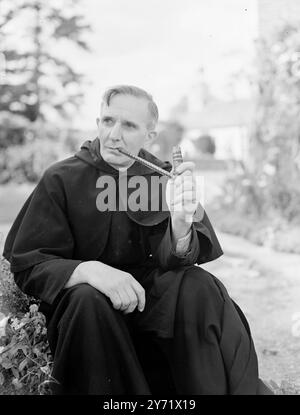 Vikar baut eigene „Smokes“ an Reverend Hugh Cuthbertson, Vikar von Tilty, in der Nähe von Dunmow, Essex, baut seinen eigenen Tabak in seinem Garten an. Der Aushärtungsprozess dauert nur zwei Monate und ist nicht durch den Klimawandel beeinflusst. Herr Cuthbertson arbeitet hart an der Förderung des Tabakanbaus in diesem Land, und mit diesem Ziel hat er den Amateur Tobacco Growers' Association gegründet, dessen Organisation er ehrenwerter Sekretär ist. Das Bild zeigt: 'Es ist auch gut' - der Rev Hugh Cuthbertson probiert eine Pfeife seines eigenen Tabaks in einer seltsamen afrikanischen einheimischen Pfeife - eine seiner Preissammlungen. 8. September 1948 Stockfoto