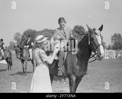 ROYAL WINDSOR HORSE SHOW die ROYAL WINDSOR HORSE SHOW, die im malerischen Home Park im Schatten von Winsdor Castle stattfindet, endete heute. DAS BILD ZEIGT:- H.R.H. PRINZESSIN ALEXANDRA VON KENT präsentiert Meister GORDON HISCOCK heute den Pokal des besten Pony in der Show in der Chocolate Box im Windsor am 15. Mai 1948 Stockfoto