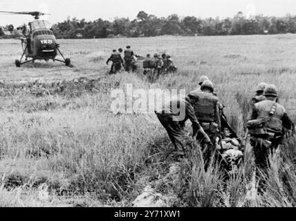 Marines tragen Verwundete zum Hubschrauber. Cam ne, Südvietnam: Die amerikanischen Marines transportieren die Verwundeten durch hohes Gras zu einem wartenden medizinischen Evakuierungshubschrauber, während einer Räumungsoperation südlich der da Nang Luftbasis. US-Beamte in Saigon berichteten heute, dass 550 Vietnam Cong bei der größten Marineaktion des Vietnamkriegs getötet wurden. US-Verluste wurden als leicht gemeldet. August 1965 Stockfoto