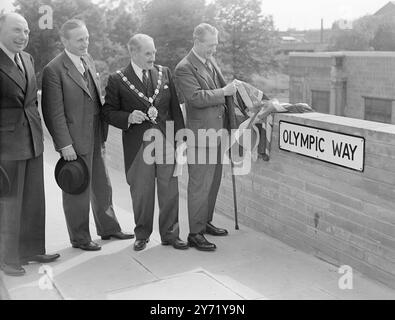 "Weg nach Olympia" - die Verkehrsminister eröffnen den Olympia-Weg. Der Verkehrsminister Alfred Barnes eröffnete offiziell die neue Straße zwischen der Station Wembley Park und dem Empire Stadium in Wembley. Um die Austragung der Olympischen Spiele in Wembley fortzusetzen, nannte der Minister den neuen olympischen Weg. Das Bild zeigt: "Sportliche Geste" - mit Lord Burghley (links) und dem Bürgermeister von Wembley zeigt der Verkehrsminister Alfred Barnes heute die Enthüllung des neuen "Olympic Way" in Wembley. Juli 1948 Stockfoto