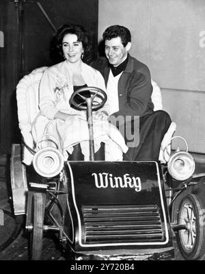 Eddie Fisher nimmt Liz mit. Sänger Eddie Fisher nimmt die schöne Witwe Elizabeth Taylor mit auf eine Fahrt im Kinderkreisverkehr in Disneyland. Das Paar brachte Liz' zwei Kinder Chris und Michael auf den Disneyland Spielplatz. Fisher trennte sich vor kurzem von seiner Schauspielerin Debbie Reynolds, und sein Name war romantisch mit Miss Taylors verbunden, deren Ehemann Mike Todd letztes Jahr bei einem Flugzeugabsturz starb. 22. Januar 1959 Stockfoto