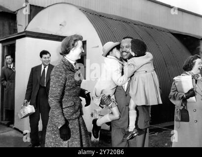 Seretse geht nach sechs Jahren im Exil nach Hause. Auf seinem Heimweg nach sechs Jahren Exil in Großbritannien verabschiedet sich Seretse Khama, der früher zum Stammesstamm der Bamangwate ernannt wurde, von seinen Kindern Jacqueline 6 und Seretse 3. vor der Abfahrt vom Flughafen London. Links lächelt seine Frau Ruth, Seretses Frau und Kinder sollen später folgen. Er kehrt in das Stammesreservat in Bechuanaland zurück, nachdem er sich freiwillig auf seinen Anspruch auf das Häuptlingsamt verzichtet hat. 9. Oktober 1956 Stockfoto