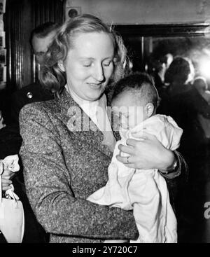 Ruth Khama und Jacqueline in London. Mrs. Ruth Khama trägt ihre drei Monate alte Tochter Jacqueline und wird heute Abend im Grosvenor Court Hotel in London als sie mit ihrem Mann Seretse Khama ankam. Seretse, designierter Chief des Bamangwato-Stammes von Bechuanaland, und seine Familie waren früher mit dem BOAC-Flugboot nach Southampton gekommen, um fünf Jahre lang aus dem Stammesgebiet zu verbannen. Mrs. Khama war früher die Londoner Schriftstellerin Ruth Williams. August 1950 Stockfoto