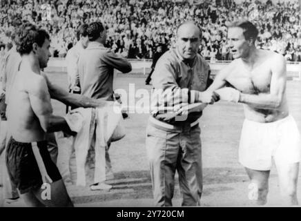 ALF in einem Tangle1966 Fußball-England-Teammanager Alf Ramsay steckte mitten im Englands George Cohen (rechts) und dem Argentinier Alberto Gonzales fest, als sie versuchen, Trikots zu tauschen, nachdem England Argentinien 1-0 im Viertelfinale in Wembley besiegt hatte. 23. Juli 1966 Stockfoto