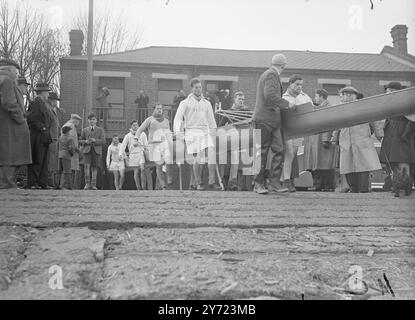 Cambridge am Tideway. Die Cambridge Eight, die für das Boat Race am 27. März trainiert wurden, hatten ihren ersten Ausflug auf dem tideway in Putney heute Morgen (Montag). Picture Shows: Mitglieder der Cambridge Crew tragen ihr Boot zum Wasser für ihre erste Trainingsrunde auf der Themse bei Putney heute Morgen (Montag). März 1948. Stockfoto