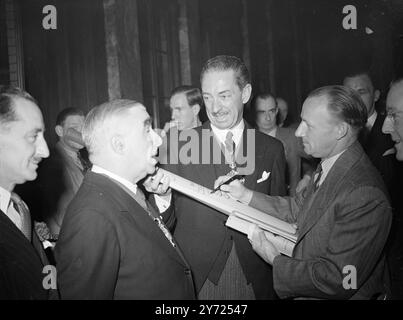 Don Bradman, Kapitän des australischen Testteams, das gestern in England ankam, signiert einen Cricketschläger, der bt Mr. Hal Gutteridge, Bürgermeister von Westminster, mit Sir Frederick Wells, Lord Bürgermeister von London, verließ. Die Fledermaus wird zur Unterstützung des Lord Mayors Appeal for Children versteigert, und der Anlass war ein Empfang für die besuchenden Cricketspieler im Australia House Thing Morning (Samstag). April 1948. Stockfoto