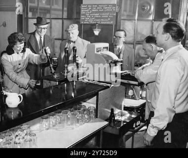 Eine Kundin holt ihr eigenes Bier im Elephant and Castle in London, England. Juni 1959 Stockfoto