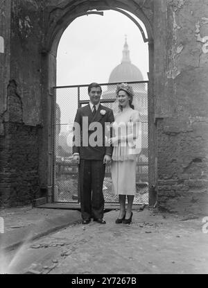 Verheiratet In Bomb Bow Bells. Die erste Hochzeit, die seit Juli 1937 in der heute bombardierten Kirche St Mary Le-Bow stattfand, fand heute (Mittwoch) statt, als Miss Noreen Purdon, die südafrikanische Sendeanstalt, mit Bill Northwood von der BBC Radio Newsreel verheiratet war. Der Pfarrer FC Baker, Kaplan des Lord Mayor, Vikar von St Stephens, Coleman Street und der verantwortliche Priester St. Mary le Bow, amtierte bei der Zeremonie. Das Bild zeigt: Ein bombardierter Bogen in der Kirche St. Mary le Bow umrahmt die ferne Kuppel von St. Paul Davor halten Braut und Bräutigam für ein Foto nach ihrer Hochzeit an Stockfoto