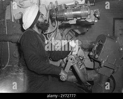 Indian Naval Men trainieren, um „Achilles“-Offiziere und Offiziere der indischen Marine zu übernehmen, die sich in England befinden, um schließlich den Kreuzer HMS zu übernehmen Achilles durchlaufen Kurse in einer Reihe von Royal Naval Establishments im Vereinigten Königreich, bevor das Schiff in Betrieb genommen wird. Zurzeit befinden sich einige von ihnen in Portsmouth, wo sie Kanonenschießen und bewaffneten Kampf auf dem „Trockenlandschiff“, HMS Excellent, lernen. Das Bild zeigt: Ein Sikh-Rating unter Ausbildung an der HMS Excellent, lernt, eine 4,7 Mark XII Waffe zu legen, ähnlich denen, die die Achillies bewaffnen. 23. Februar 1948 Stockfoto