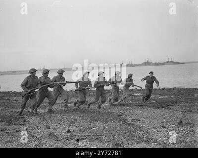 Indian Naval Men trainieren, um „Achilles“-Offiziere und Offiziere der indischen Marine zu übernehmen, die sich in England befinden, um schließlich den Kreuzer HMS zu übernehmen Achilles absolvieren Kurse bei einem humber of Royal Naval Establishments im Vereinigten Königreich, bevor das Schiff in Betrieb genommen wird. Zurzeit befinden sich einige von ihnen in Portsmouth, wo sie Kanonenschießen und bewaffneten Kampf auf dem „Trockenlandschiff“, HMS Excellent, lernen. Das Bild zeigt: Ein bewaffneter Angriff der indischen Marine bei HMS Excellent. Die Männer stehen unter der Anweisung von Sgt. A. R Claydon DSM Royal Marines auf der rechten Seite. 23. Februar 1948 Stockfoto