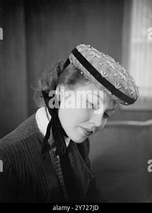 Muffin-Zeit. Film Star Hazel Court sieht pikant aus in diesem frivolen kleinen Muffinmütze mit Stickerei aus rosa Filz. Die Dekoration besteht aus Perlenperlen und ein blaues Samtband umgibt die Krempe, um sie herum zu bringen und unter dem Kinn fest zu binden. 26. Februar 1948 Stockfoto
