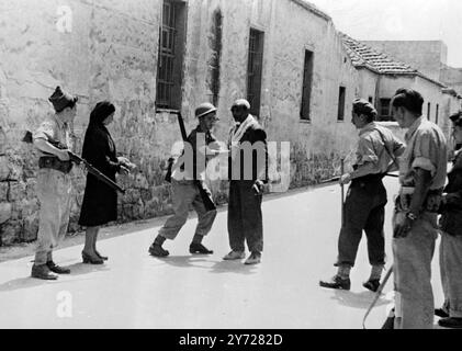 Dies sind die ersten Bilder, die von Haifa seit der jüdischen Eroberung der Stadt empfangen wurden. Der einzige Teil, der nicht besetzt war, war der britische Hafenbereich. Nach einem Halt an einer Haganah-Barrikade wird dieses arabische Paar befragt und durchsucht und darf dann fortfahren, während sie die jüdische Stadt evakuieren. 11. Mai 1948 Stockfoto