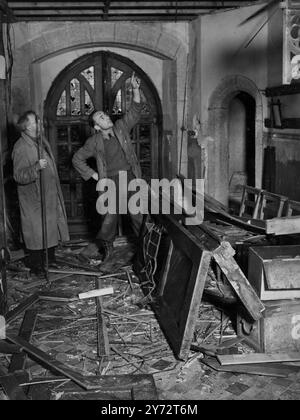 Ein schwerer Sturm, der den Süden von Devon heimsuchte, traf die normannische Kirche von Newton Ferrers und verursachte schwere Schäden am alten Gebäude. Die Wildheit des Sturms riss von der Ecke des bleihaltigen Daches und schleuderte riesige Steinblöcke auf den Boden. Das Bild zeigt: Schwere Holztüren, geknickt und zertrümmert, die man im mit Trümmern übersäten Schiff der Pfarrkirche Newton Ferrers in South Devon sieht, nachdem der Sturm vorbei war. 4. Dezember 1946 Stockfoto