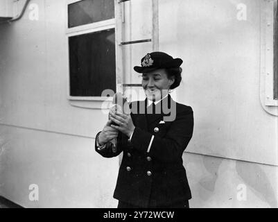 Als die Cunnard-White Star RMS Queen Elizabeth eines Tages aus Southampton auf ihrer Jungfernfahrt nach New York auszog und erschöpfte Zieltaube auf dem Bootsdeck des Schiffes gefunden wurde. Der Vogel ist jetzt in guten Händen im Schiff und wird nach England gebracht, wo er beim Anlegen des Schiffes freigelassen wird. Das Bild zeigt die Taube, die in der Obhut einer der weiblichen Offiziere von Queen Elizabeth, Ms. Davies, von Bristol ist. 23. Oktober 1946 Stockfoto