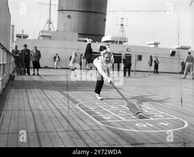 Mrs. Patricia Wykes hat einen eigenen Stil, während sie Shuffleboard und das Sportdeck der Queen Elizabeth spielt. Ein mittelatlantisches Bild aus der riesigen Mine bot eine Jungfernfahrt von Southampton nach New York an. - 23. Oktober 1946 Stockfoto