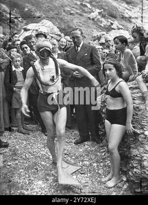 Frogman neuer STYLE. Der 68-jährige, ehemalige Pariser Barrister Monsieur Daniel P Causteau Flaps ist weit hinunter zum Strand von Torquay, Devon, um zum ersten Mal in Großbritannien ein neues leichtes Tauchen-Outfit zu demonstrieren, die Erfindung seines Sohnes, Lt. Commander M. Jacques Yves Cousteau. Der Anzug, der aus nassen Füßen, einer großen Maske und einem Behälter mit Druckluft besteht, der auf dem Rücken umschnallt und mit einem Rohr am Mund befestigt ist, ermöglicht es dem Taucher, lange Zeit unter Wasser zu bleiben und dabei volle Bewegungsfreiheit zu haben. Bei der Torquay-Demonstration blieb Vater Cousteau für bescheidene neun Minuten unter, aber er ist erfunden Stockfoto