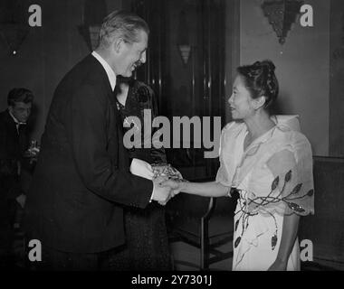 Krankenschwestern aus allen Teilen der Welt wurden gestern Abend im Claridges Hotel in London von britischen Krankenschwestern bei einem Abendessen unterhalten, das von der Zeitschrift "The Nursing Times" des Royal College of Nursing organisiert wurde. Herr Harold Macmillan, Abgeordneter, führte den Vorsitz beim Abendessen, bei dem die Gäste Mitglieder des Verwaltungsrats des International Council of Nurses waren, der jetzt in London zusammentritt. Das Bild zeigt: Herr harold macmillan begrüßt Frau de Guzman (filipino) zum Abendessen. 5. September 1946 Stockfoto