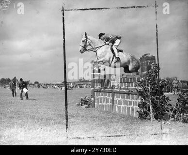 Bei Christchurch Horse Show. In der Christchurch (Hants). Die Pferdeschau, die auf dem Gelände des Flugplatzes stattfindet, kam von allen britischen Inseln. Das Springen und andere Klassiker. Es war zu Hilfe des Fonds "Lest We Forget". Das Foto zeigt, dass Mr. G Fisher einen der Sprünge auf „The Count“ in der Klasse A Open Jumping Class in Christchurch abholte, für die 80 Pferde aus England, Schottland, Irland und Wales zugelassen wurden. August 1946 Stockfoto