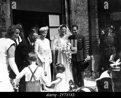 Königliche Hochzeit in der Kapelle. Die Hochzeit fand heute, Freitag, in der Chapel Royal, St James's Palace, London (mit Erlaubnis des Königs) zwischen Maj Richard Christopher Sharples und Miss Pamela Newall statt. Das Foto zeigt, dass Ihre Majestät Königin Mary und die jungen Brautbegleiter sahen, wie Braut und Bräutigam die Kapelle Royal verließen, nach ihrer Hochzeit heute. 12. Juli 1946 Stockfoto