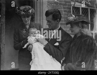 Eine riesige Menge von Filmfans mobbte Stewart Granger und seine Frau in der malerischen Linchmere Church in Haslemere, wo ihre kleine Tochter Lindsay getauft wurde. Sally Gray war als Patenmutter des Kindes anwesend, aber auch James Mason und John Mills konnten nicht dort sein. Das Foto zeigt die Taufgruppe. Stewart Granger hält Lindsay mit Mrs. Granger (links) und Patenmutter Sally Gray. 5. Mai 1946 Stockfoto