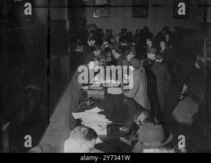 Kunden, die Kataloge mit Agenten der Reiseagentur Thomas Cook, London.1946, durchsehen Stockfoto