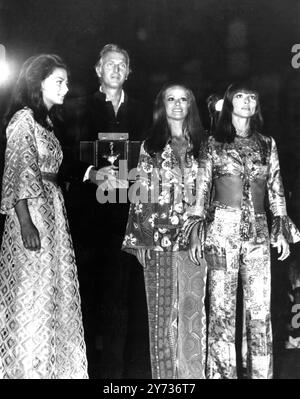 Der französische Designer Hubert de Givenchy zeigte mit Schauspielerinnen (von links nach rechts) Prinzessin Ira Furstenberg , die französische Claudine Auger und die italienische Elsa Martinelli , nachdem er am 12. September auf der Maremoda Sea Fashion Show auf der Insel Capri den Goldenen Tiberius als bester Deisgner ausgezeichnet worden war . Viele berühmte Stars und Mitglieder des europäischen Jetsets nahmen an der Show Teil. 14. September 1969 Stockfoto