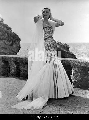 Jacques Fath hatte die erste öffentliche Vorstellung seiner neuen Winterkollektion im smarten Sommerresort Biarritz in Südfrankreich . Fotoshows: Ein glitzerndes weißes Abendkleid aus Satin namens " Le Bal " , eines der am meisten applaudierten Kleider der Wintersaison . Kupfergoldene Perlen bedecken das trägerlose Kleid von der Brust bis zum Knie. 25. September 1950 Stockfoto