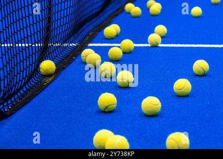 Paddeltennis und Tennisbälle auf dem blauen Platz. Horizontales Sportplakat, Grußkarten, Kopfzeilen, Website Stockfoto