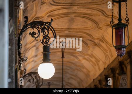 Vintage-Außenlampen. Vintage-Lichter in einer alten Bogengalerie. Bogengang am Abend. Stockfoto