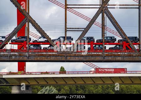 Die Beeckerwerther Rheinbrücke der Autobahn A42, LKW-Verkehr, davor die Haus-Knipp Eisenbahnbrücke, Güterzug, Autozug, Neuwagen von t Stockfoto